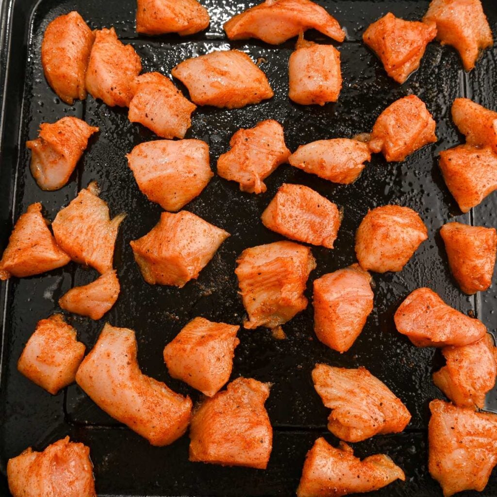 hot honey chicken bites on an air fryer tray.