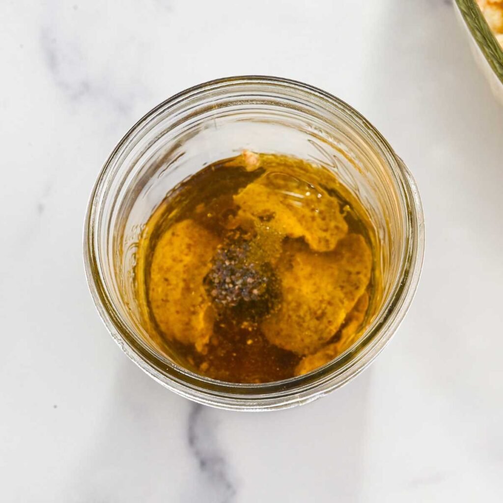 vinaigrette in a glass jar on a white background.