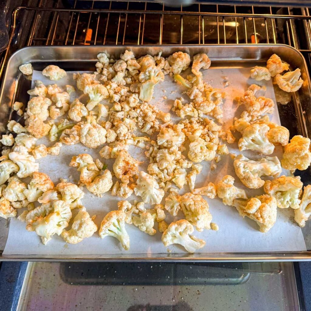 pan of cauliflower florets to be roasted for cauliflower salad.