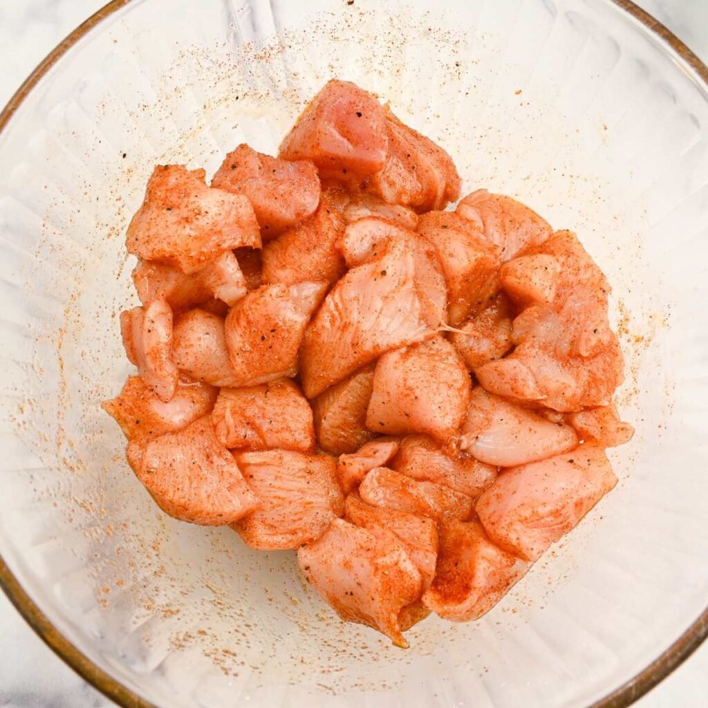 seasoned chicken bites in a glass bowl.