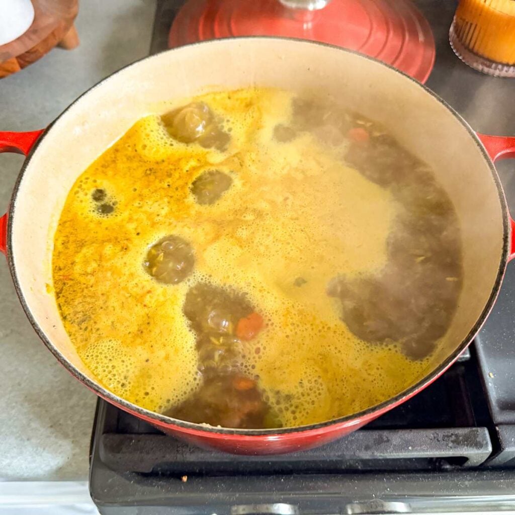 boiling chicken broth in a Dutch oven.
