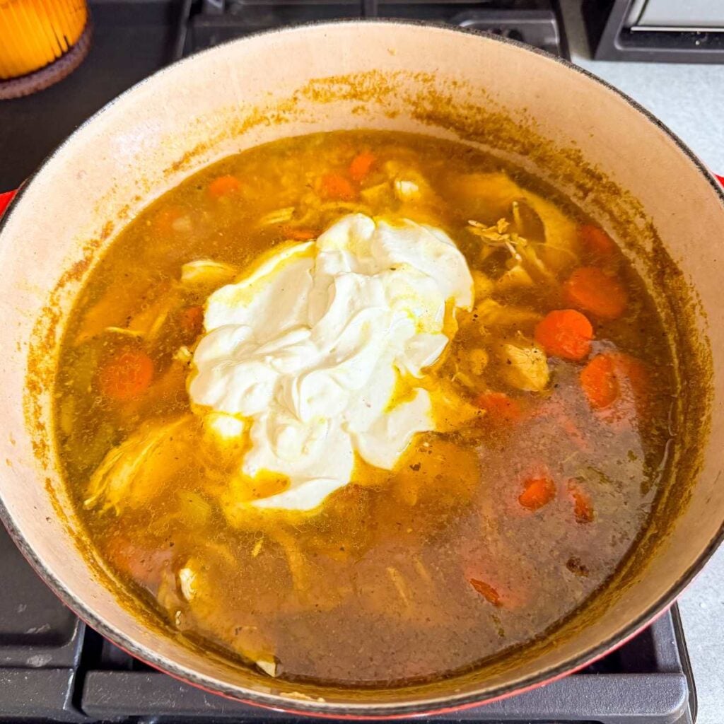 Chicken and brown rice soup with Greek yogurt in a Dutch oven.