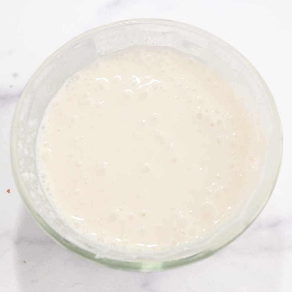 blended cottage cheese and almond milk in a glass bowl.