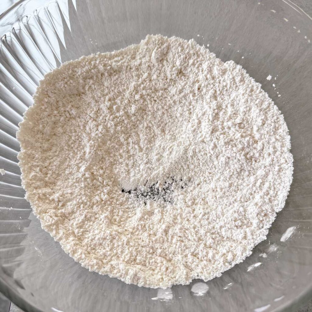 greek yogurt lemon blueberry cake ingredients in a glass bowl.