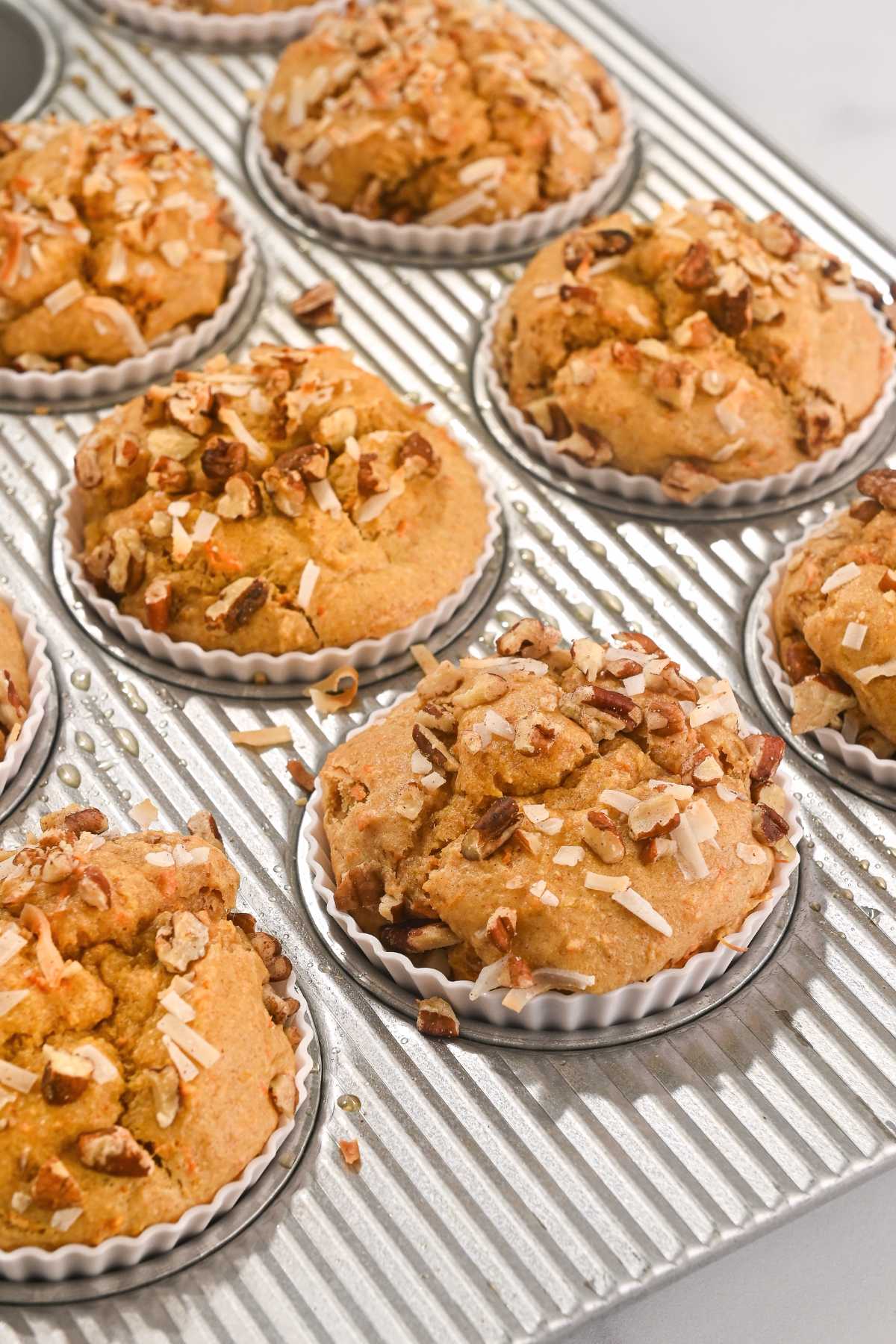 healthy carrot cake protein muffins in a muffin tin.