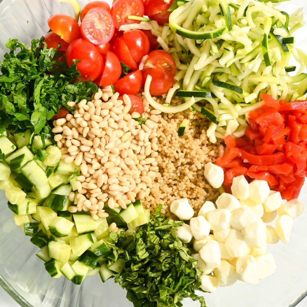 prepared italian quinoa caprese salad ingreidents in a glass bowl.