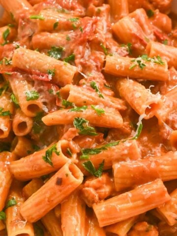 close up shot of lobster bisque pasta topped with fresh basil and parmesan cheese.