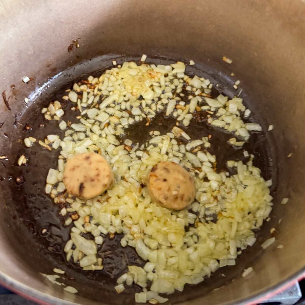 shallots and garlic simmering in a pan.